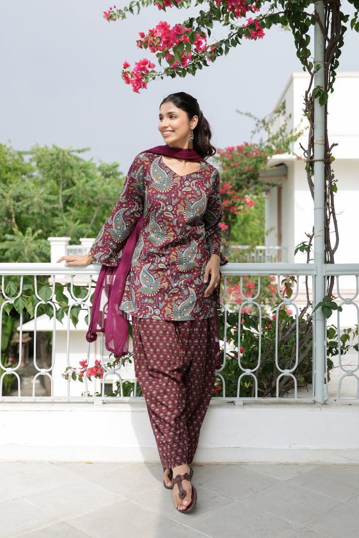 Side view of Nargis wine paisley kurta and pleated floral print Farshi salwar suit set by Gulaabgali